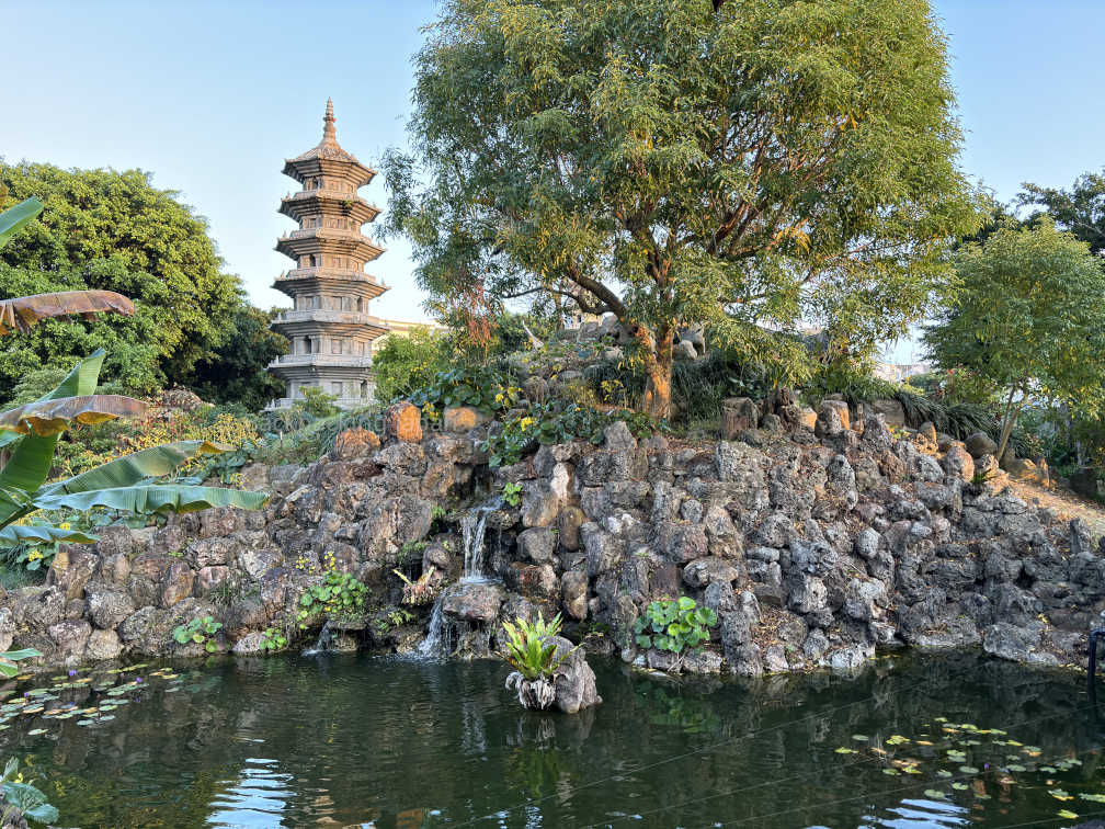 Fukushuen garden, looking towards a lake, a mini-hill with many plants and trees, and a stone pagoda