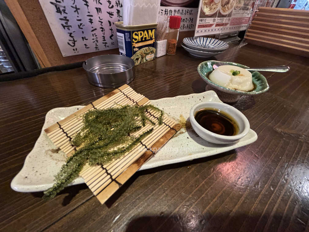 Umibudo (sea grape seaweed) and jimami dofu (peanut tofu) on a bar countertop